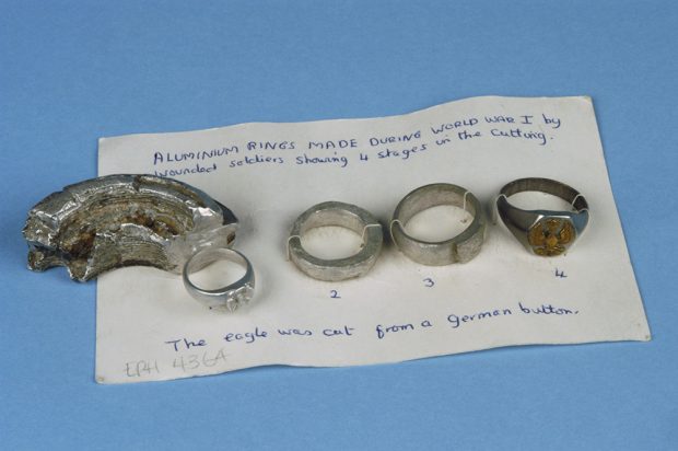 Four aluminum rings on a recipe card with handwritten text. Three of them are completed and one is nearly completed.