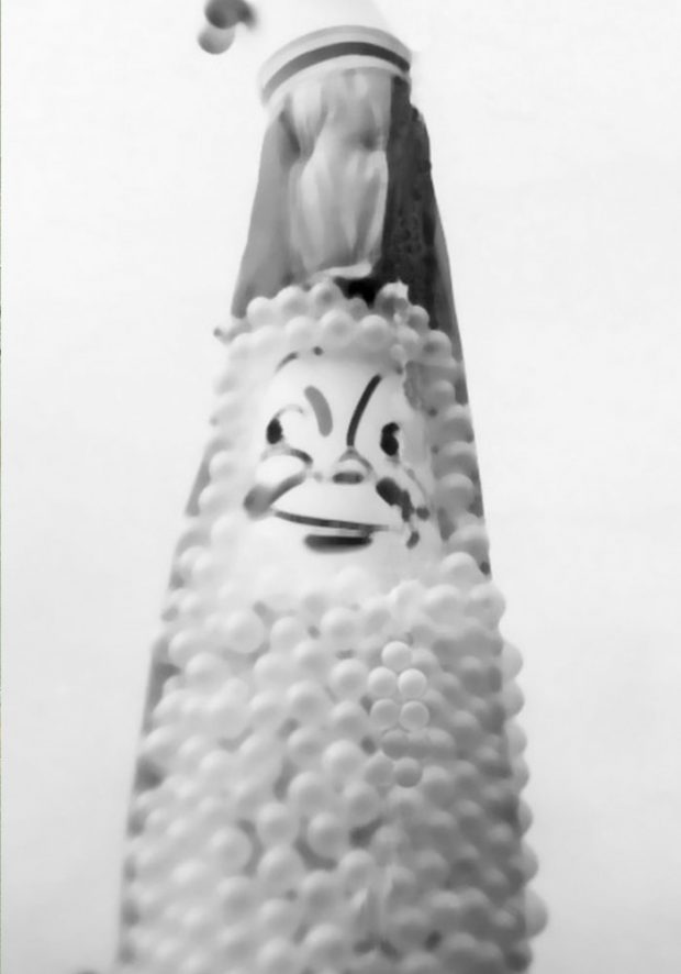 Black and white photograph of the Agassiz Fall Fair and Corn Festival mascot. It has a painted face and is made out of balloons.
