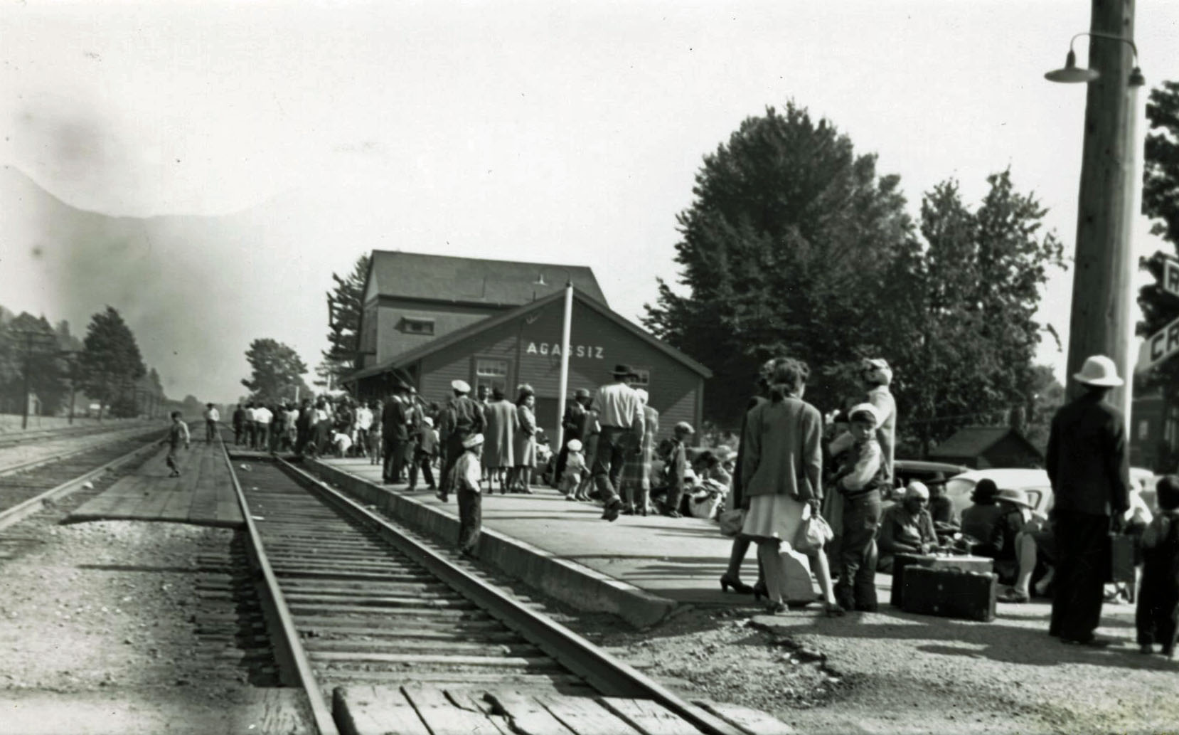 Black and white photograph of a crowd of people on the Agassiz train station platform.