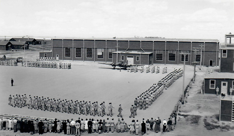 Five groups of military men on parade ground with crowd watching