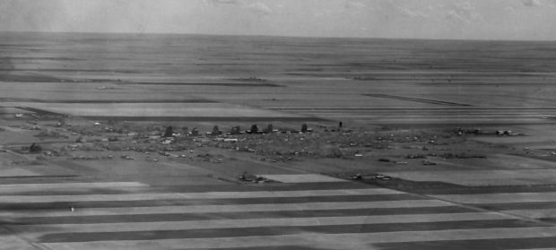 Aerial view of town, grain elevators and farmland