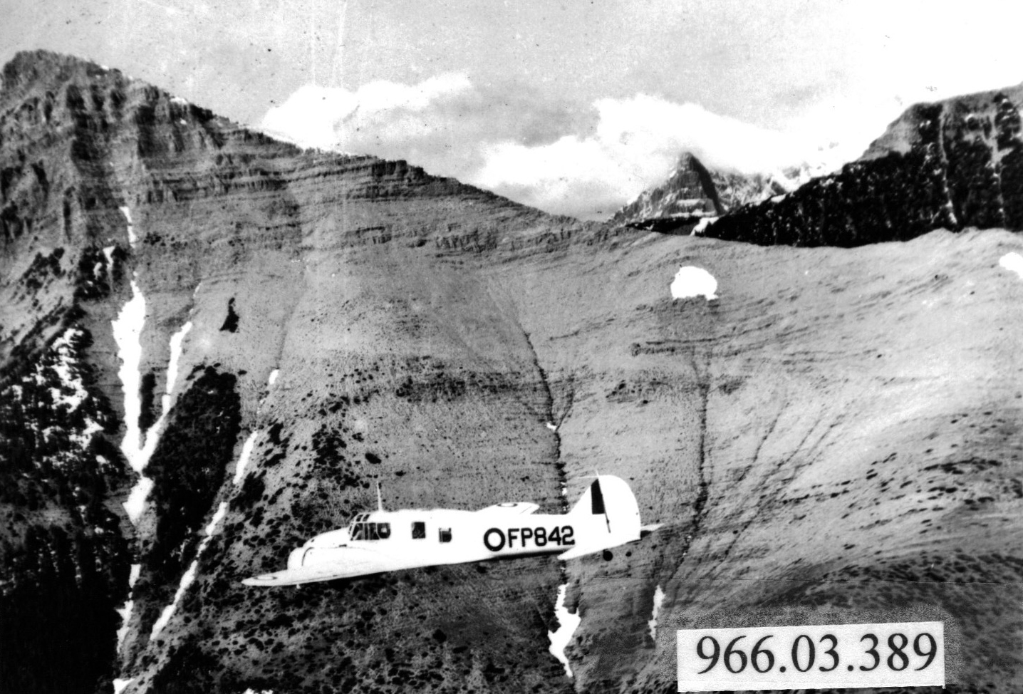 Airplane flying in front of mountains