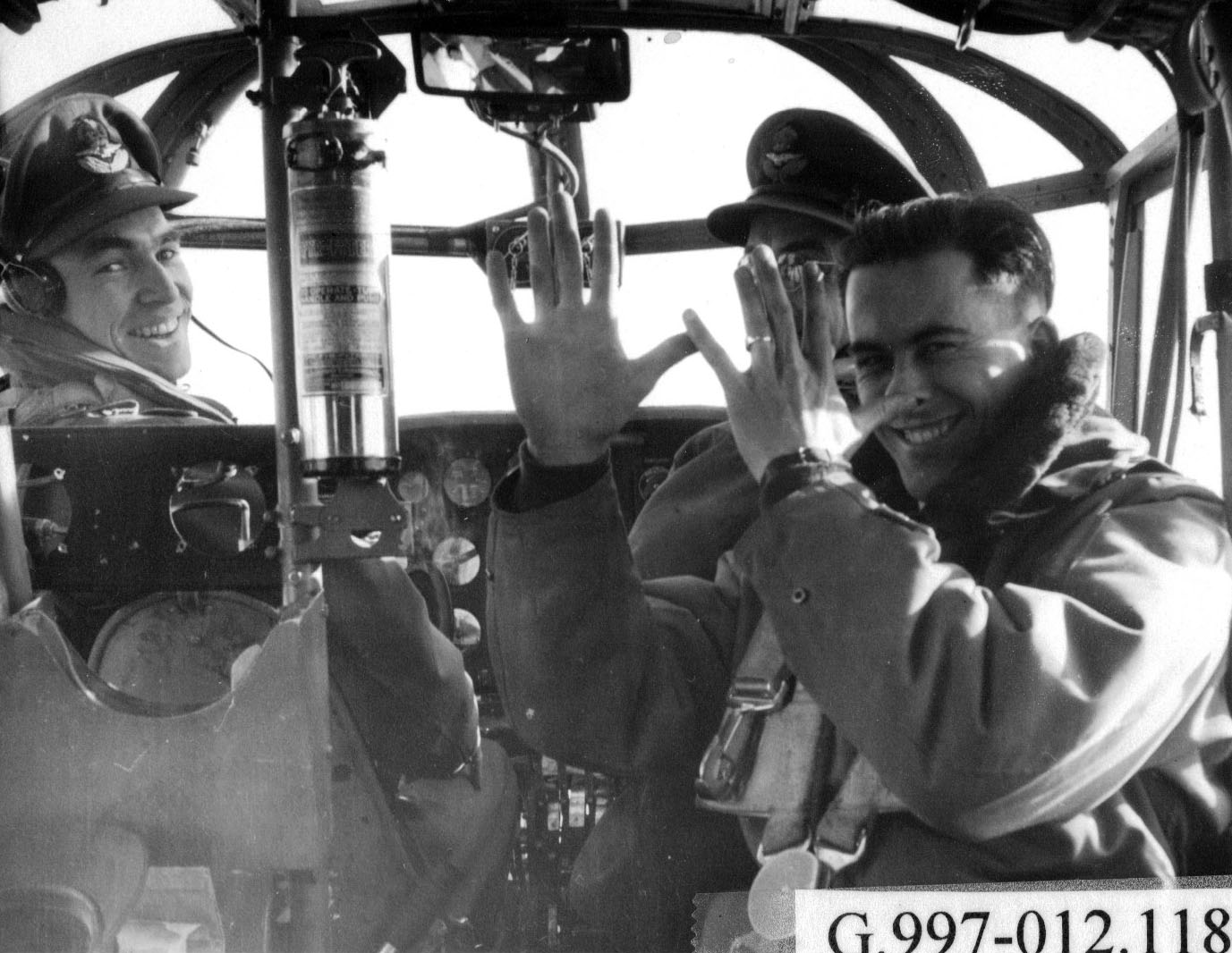 Deux pilotes des forces aériennes et un instructeur dans le poste de pilotage d’un avion, années 1940