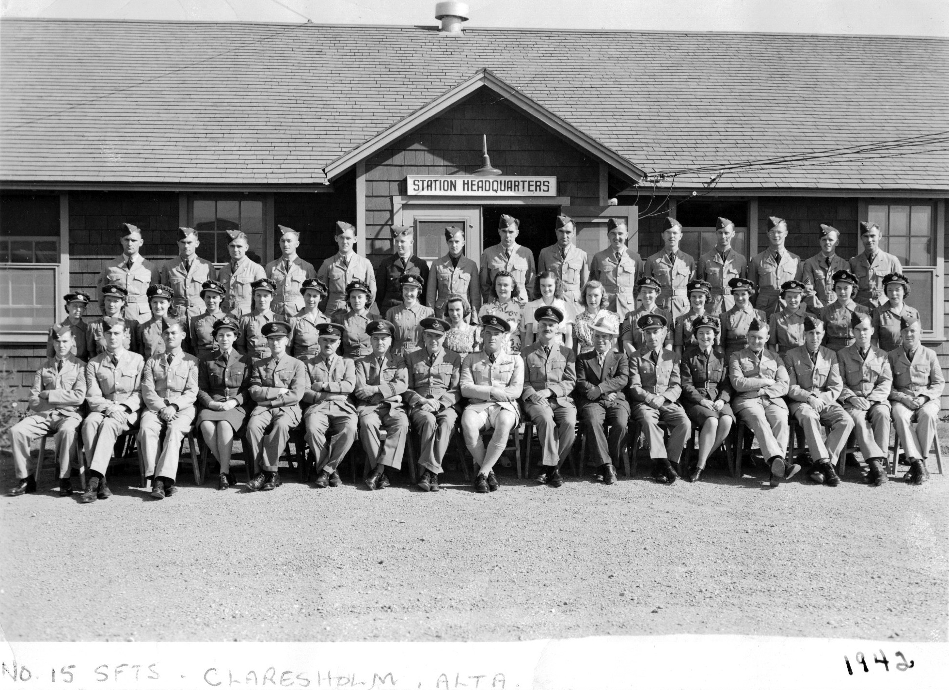 Group photo of military men and women in front of station headquarters