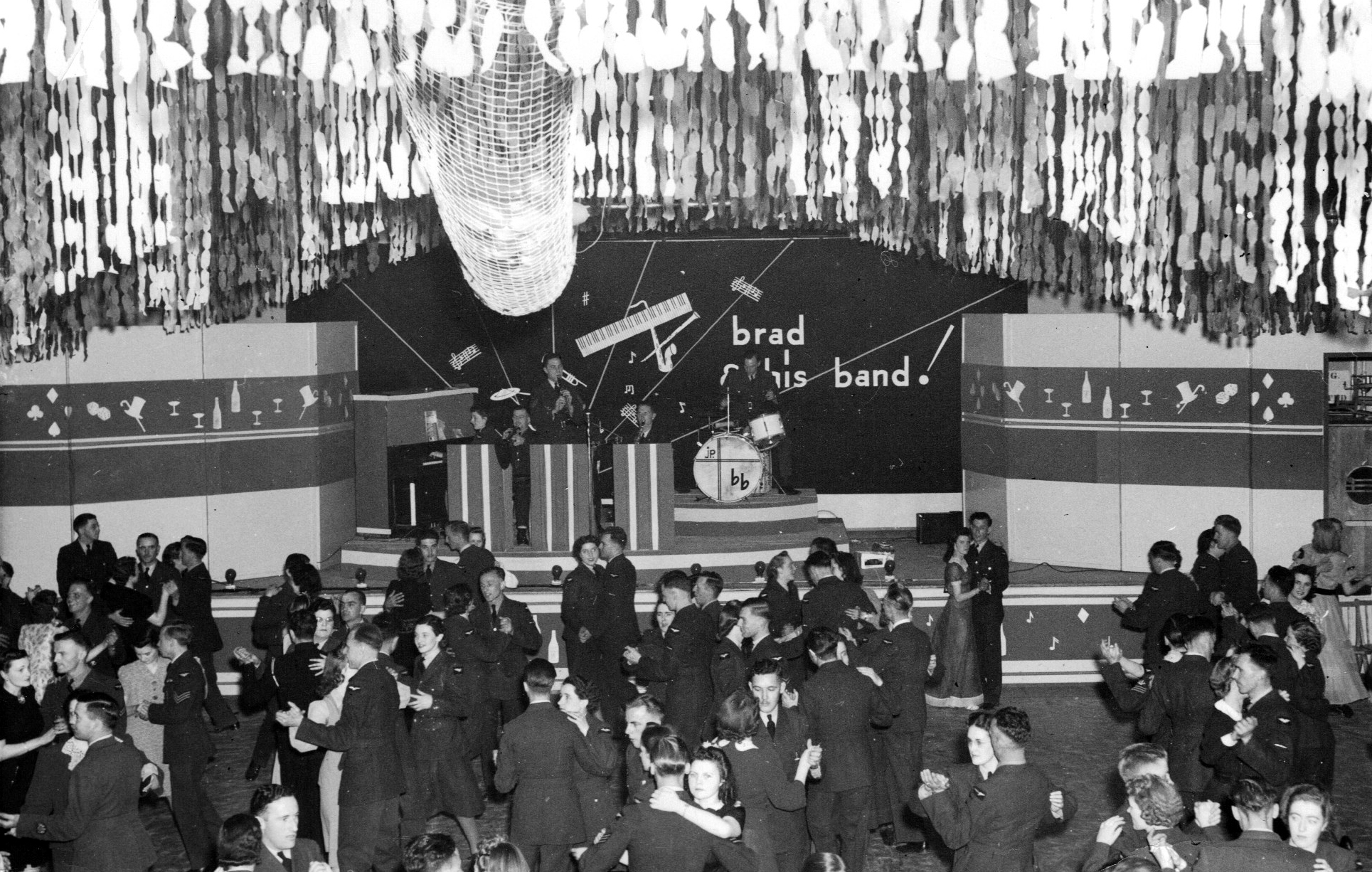 multiple couples dancing to a band on a stage