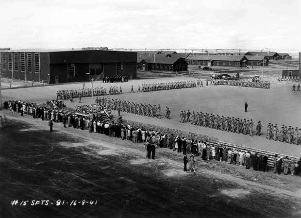 fsix groups of military men marching on parade square with crowd watching