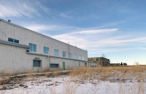 four old airplane hangars with snow on ground