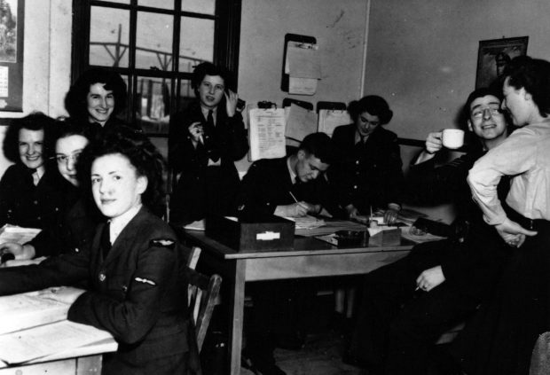 7 airwomen and and 2 airmen working in office.