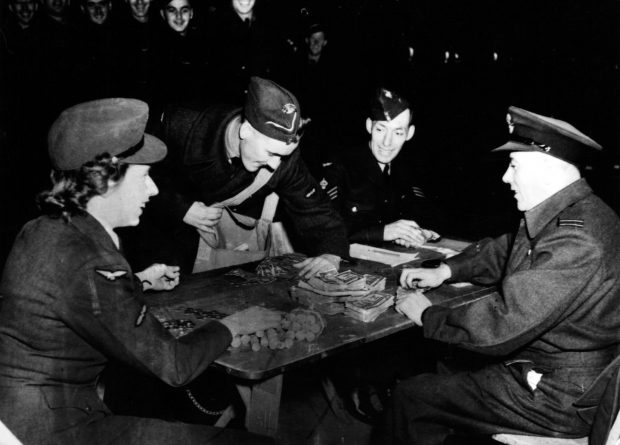 3 airmen and one airwoman counting money on a table