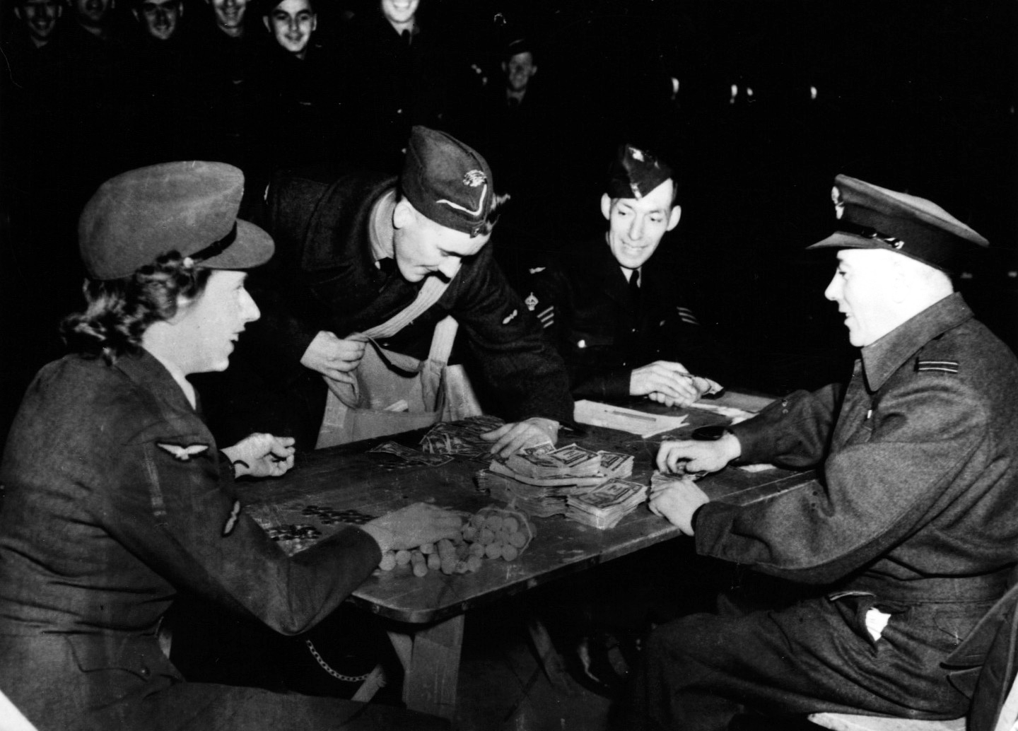 3 airmen and one airwoman counting money on a table