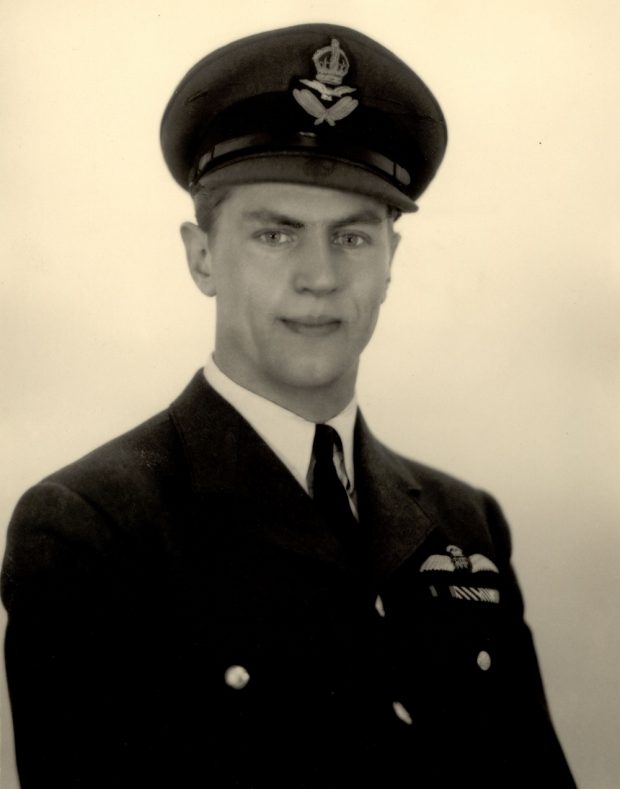 Black-and-white photo of a man posing in a military uniform.