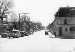 Cinq automobiles circulent sur la rue principale 