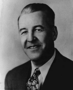 Photo of Léo Papin, smiling, in a suit and tie.