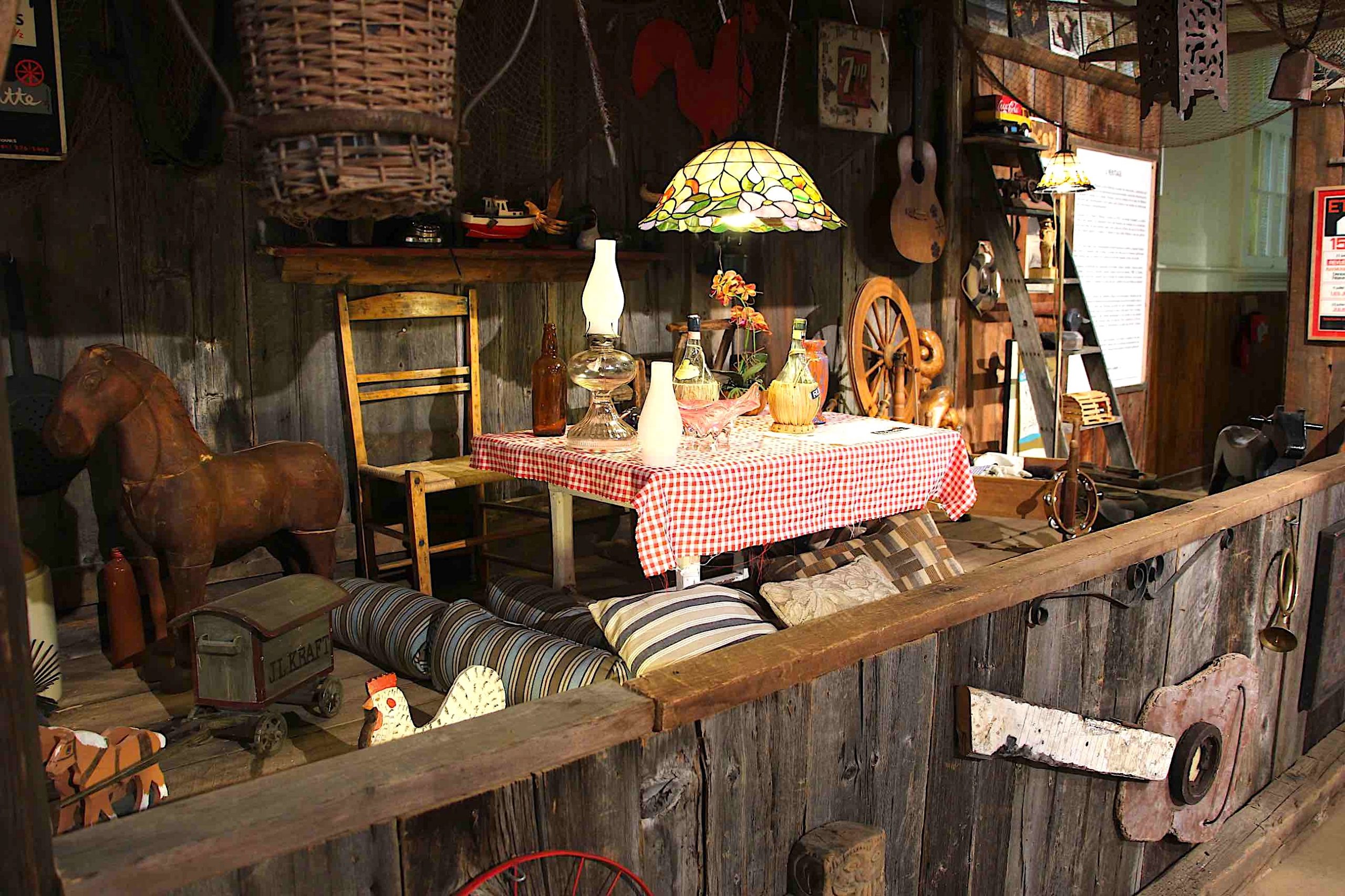 Color photo of the 2021 exhibition on La Butte à Mathieu where a reproduction of a mezzanine and barn wood walls allowed to exhibit texts, photos and artefacts.