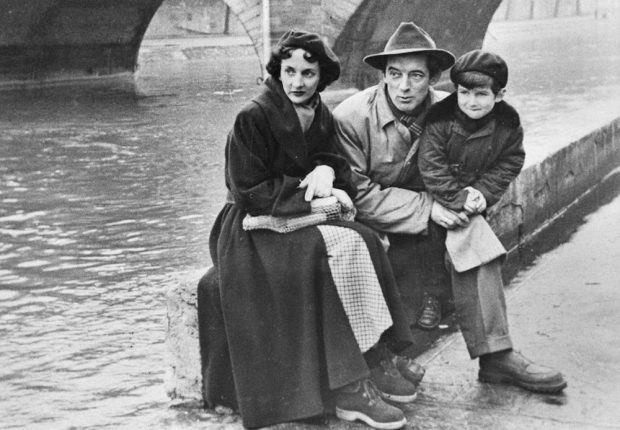 Black and white photo of Félix Leclerc, his wife and son in Paris on the banks of the Seine in the 1950s.