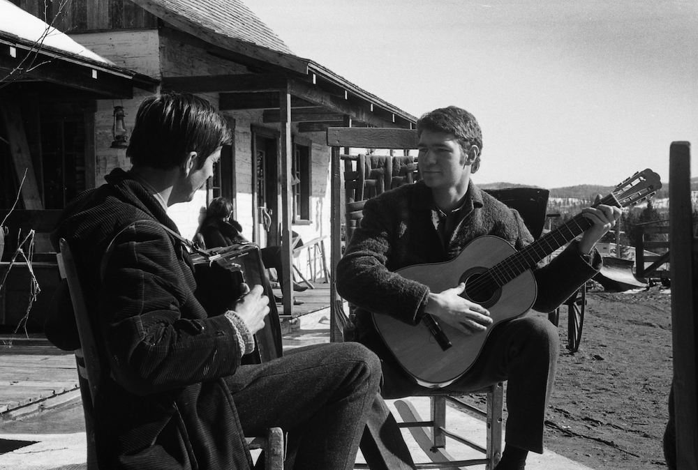 Black and white photo of Gilles Mathieu on accordion and Robert Charlebois on guitar sitting outside La Butte.