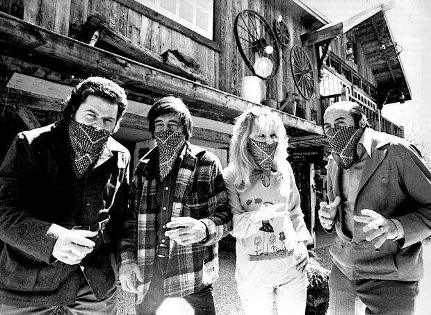 Black and white photo of three actors: Claude Michaud, Lise Thouin and Raymond Lévesque, plus Gilles Mathieu, all disguised as bandits outside La Butte.