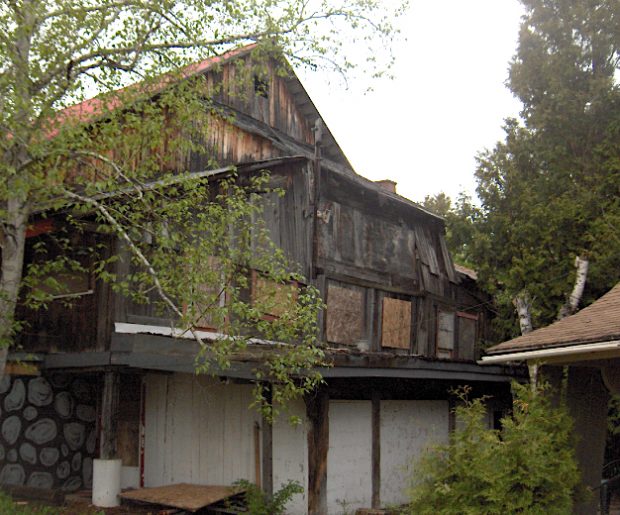 Colour photo of La Butte abandoned and plastered in 2004. The place is dilapidated and falling into ruin.