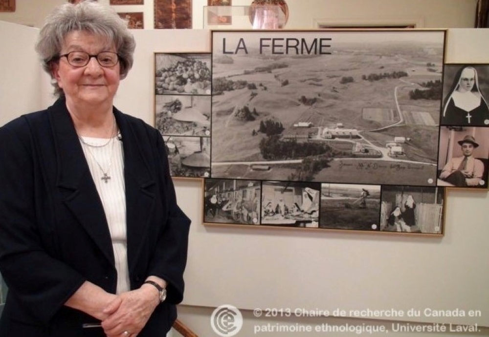 Woman standing in front of photographs of the farm.