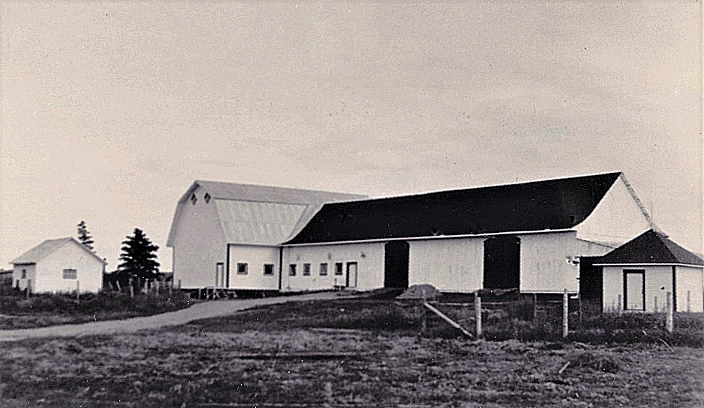 Black and white photo of a rectangular building with a gable roof.