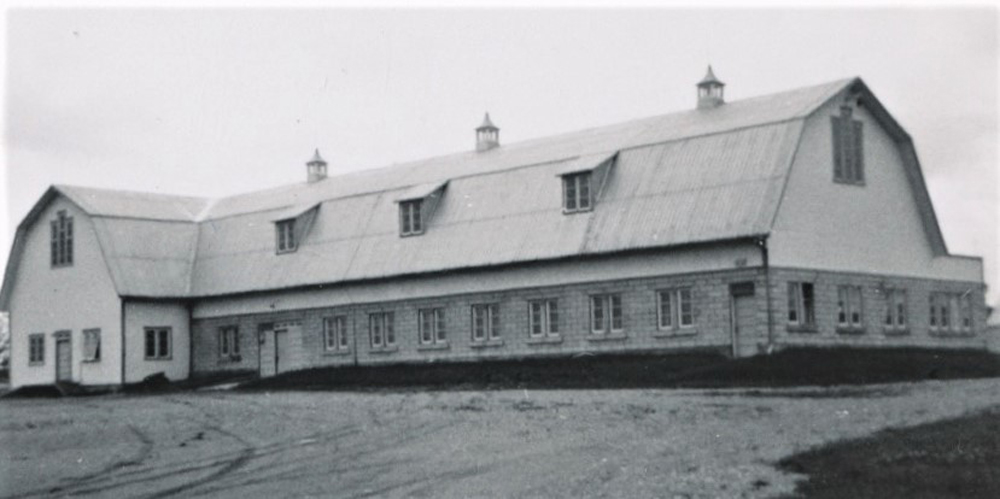 Greyish photo of a building with damaged roof.