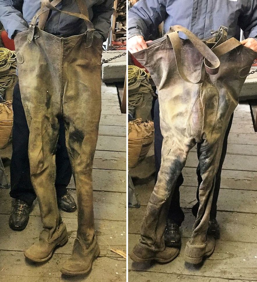 Front and back views of a pair of boot-foot waders with suspenders, made entirely from the hide of a horse’s hindquarters. A man is holding the waders upright.