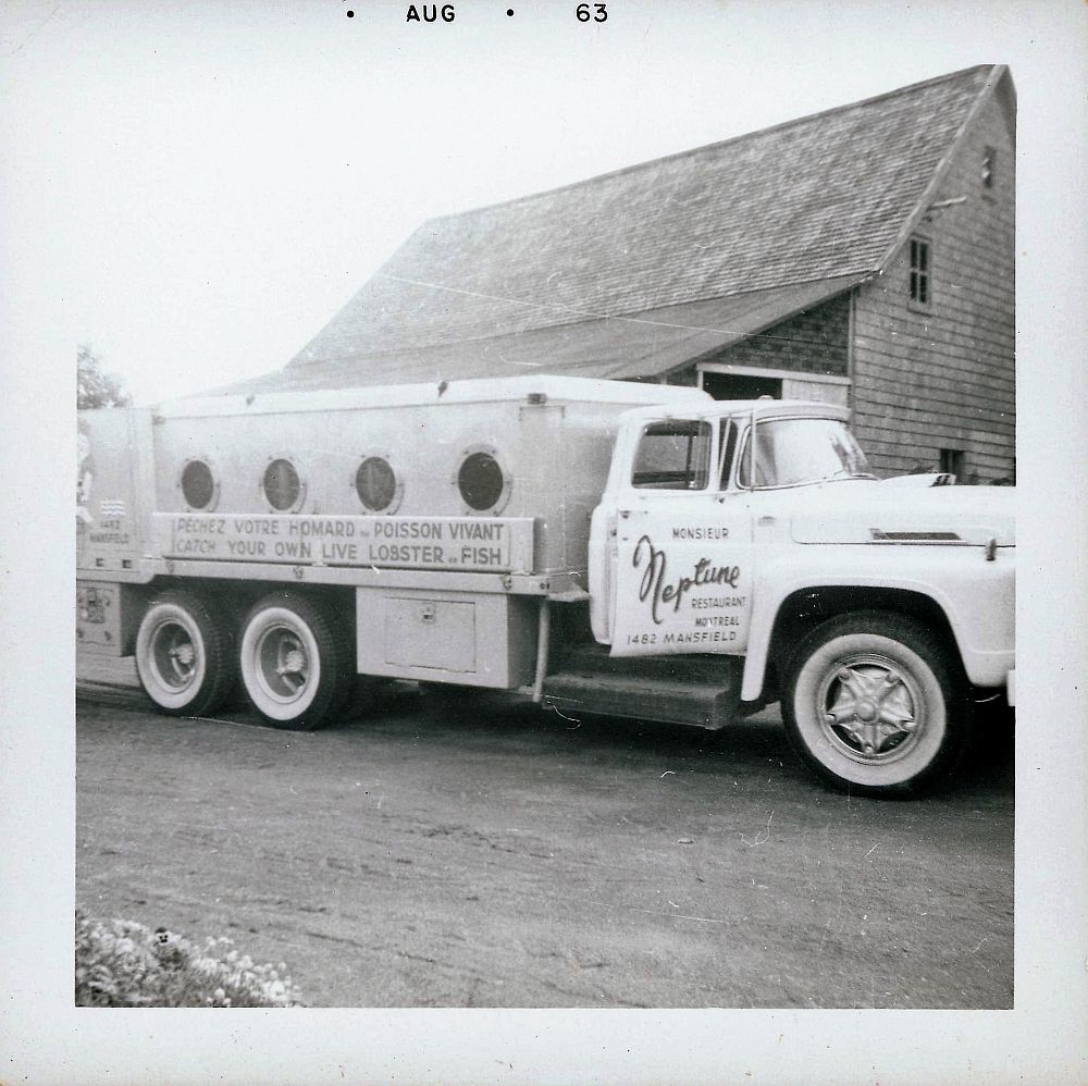 Camion-citerne utilisé pour le transport du poisson vivant. On peut lire sur le côté « Neptune Restaurant Montréal. Prenez votre homard et poisson vivant »; photo noir et blanc.