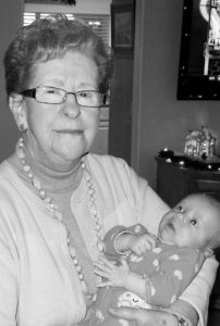 Black and white photo, Mrs. Monique Farrar holding a baby in her arms.