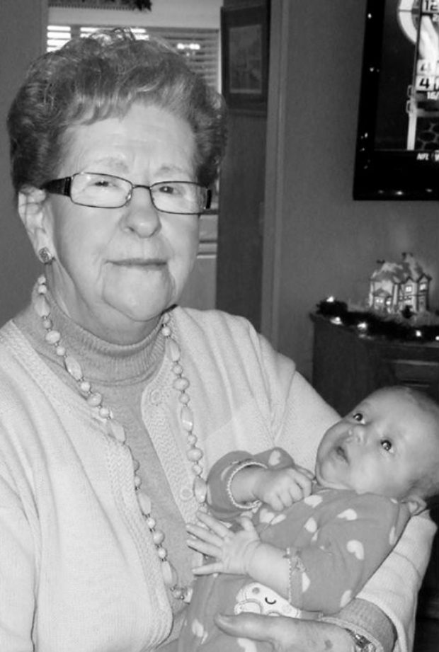 Photo en noir et blanc, madame Monique Farrar tenant un bébé dans ses bras..