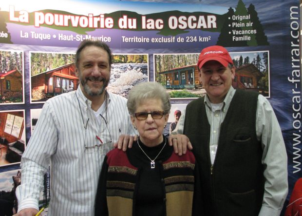 Photo couleur prise lors d'un salon promotionnel en 2013.  Monique Farrar entourée de ses deux fils Donald et Jean-Claude.