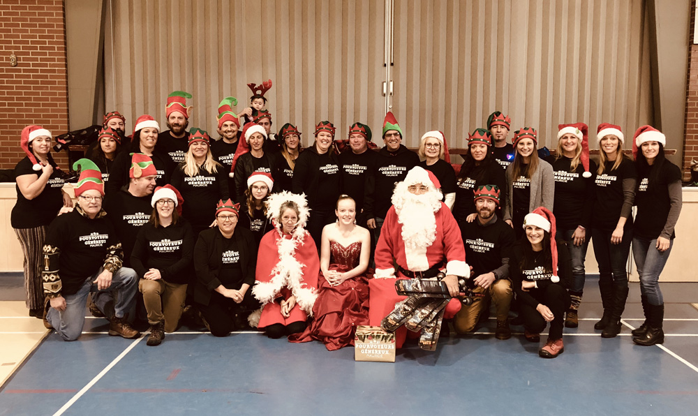 Photo couleur, un groupe posant fièrement lors d'une fête de Noël.