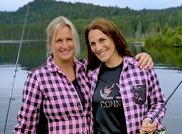 Two girls holding a fishing rod.