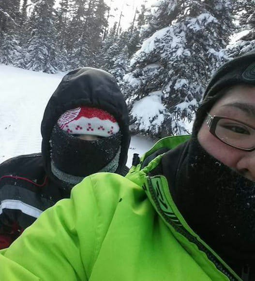 Close-up of two people wearing winter jackets in snowy forest