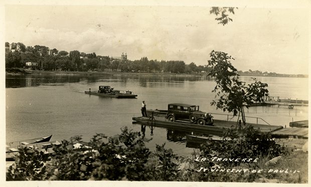 Sepia vintage photograph. It shows two cars on two reaction ferries that travelled between the eastern end of Île Jésus and the village of Sault-au-Récollet on the Island of Montreal. In the lower right-hand corner, the following handwritten words appear: “La traverse Saint-Vincent-de-Paul” [Saint-Vincent-de-Paul ferry].