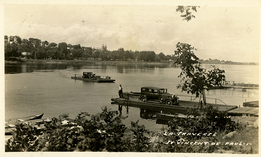 Sepia vintage photograph. It shows two cars on two reaction ferries that travelled between the eastern end of Île Jésus and the village of Sault-au-Récollet on the Island of Montreal. In the lower right-hand corner, the following handwritten words appear: “La traverse Saint-Vincent-de-Paul” [Saint-Vincent-de-Paul ferry].