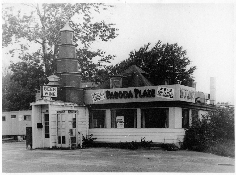Black and white photograph of a small restaurant serving Chinese and Canadian food called Pagoda Place.