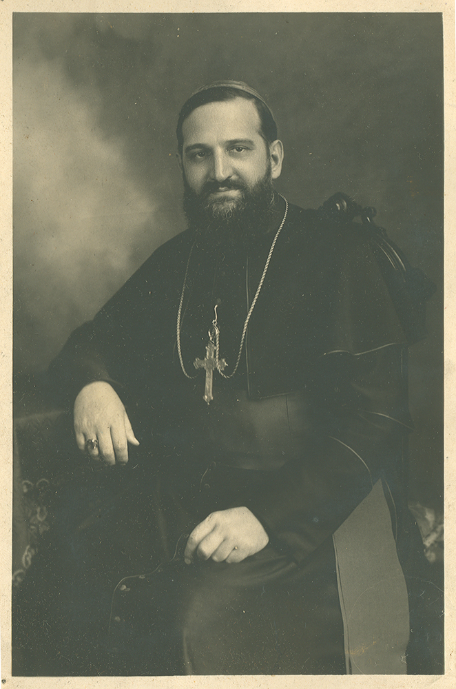 Black and white picture of Bishop Alfred LePailleur. He is seated in an armchair in the setting of a photo studio.