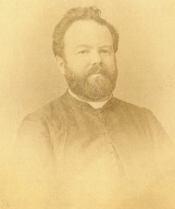 Photo sépia pâle de Georges-Marie LePailleur alors qu'il était prêtre. Il porte une courte barbe et un col romain.