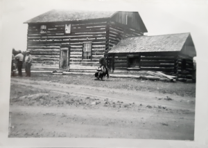 Men in front of wooden cabin