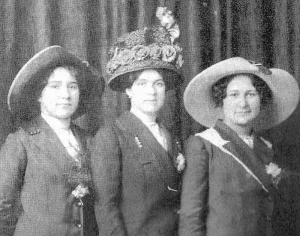 Three women wearing coats and hats