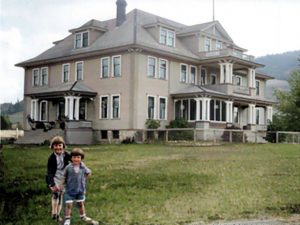 Two children on lawn of three-storey building