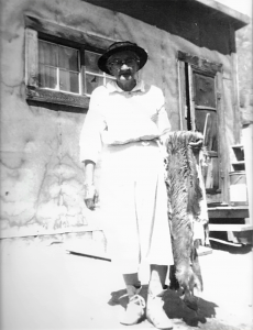 Woman holding fur in front of house