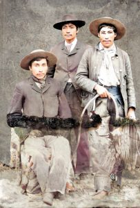 Studio photo of three cowboys in gear