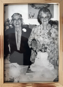 Seated couple cutting an anniversary cake