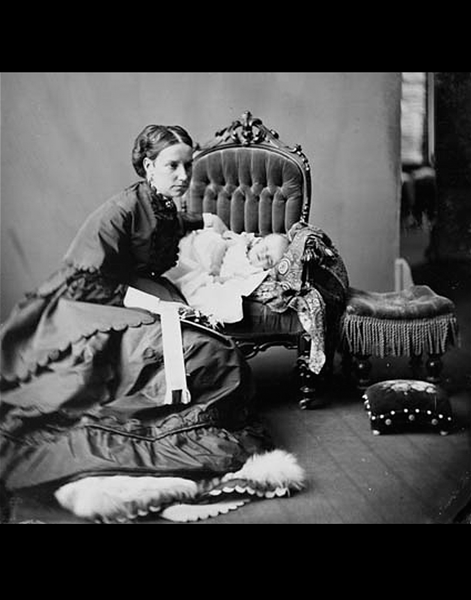 Lady Agnes Macdonald crouches next to a chair in which her baby Mary is propped, 1868.