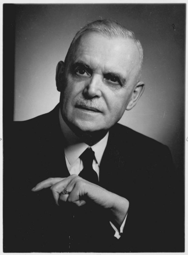 Black and white portrait of the head and shoulders and arm of Louis St. Laurent in a suit and tie, with receding grey hair, dark eyes and an authoritative expression.
