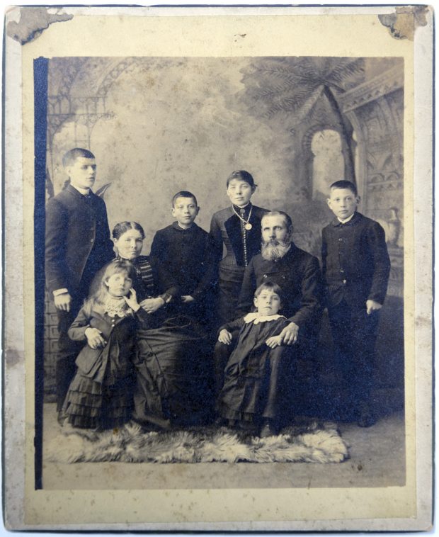 Formal portrait of seven people posed in a photography studio