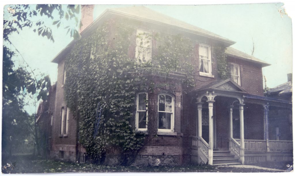Image of large brick house covered in vines