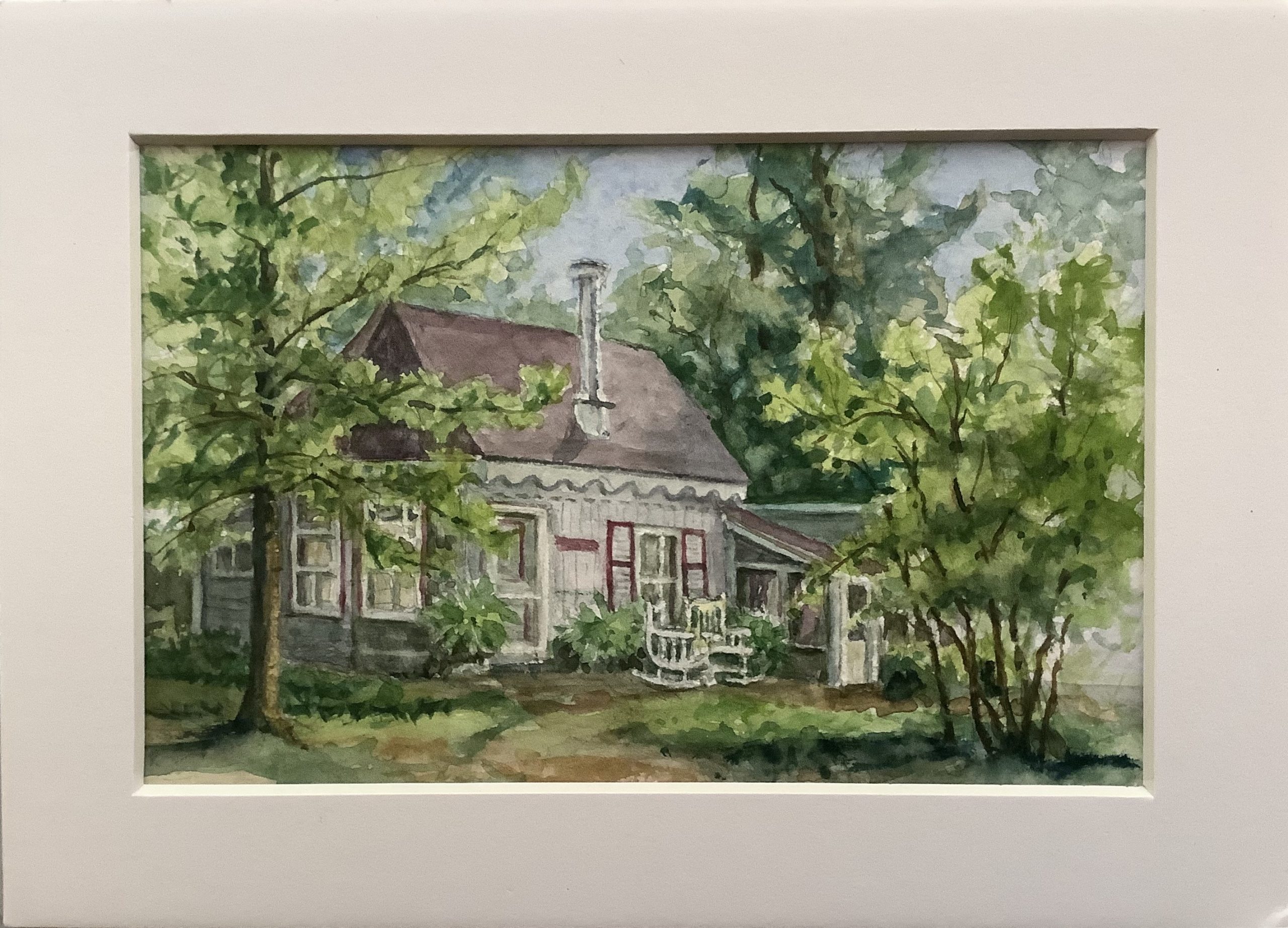 Image of cottage surrounded by trees