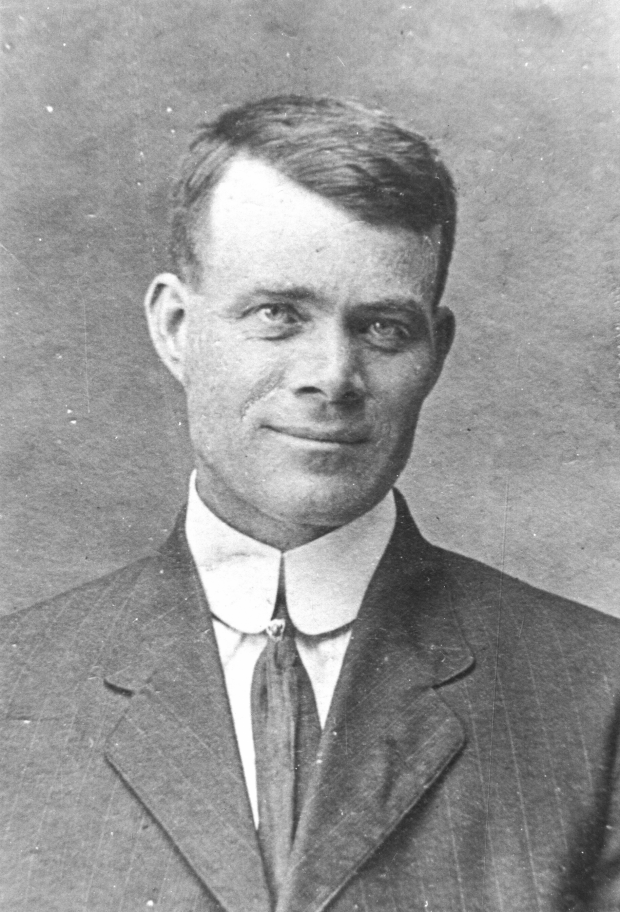 Black and white archival photograph of a man wearing a suit, and tie.